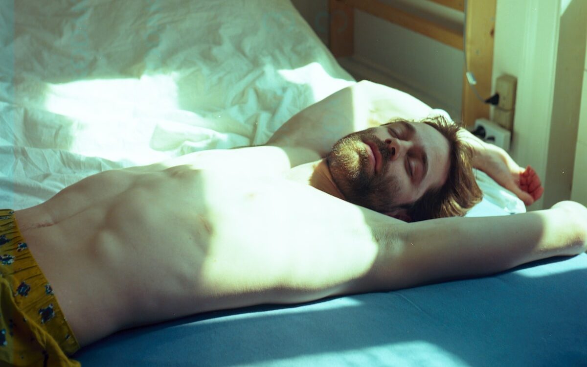 topless man lying on bed